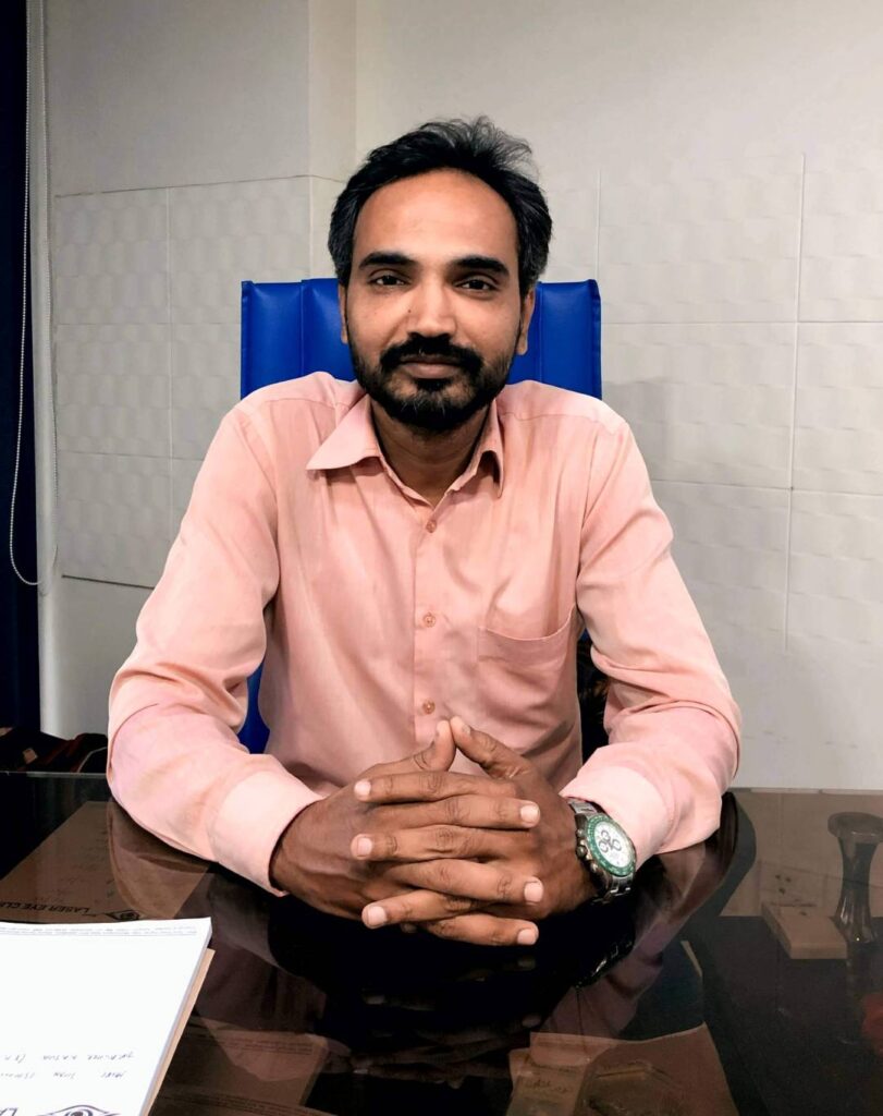 Dr. Ashok sitting on his desk